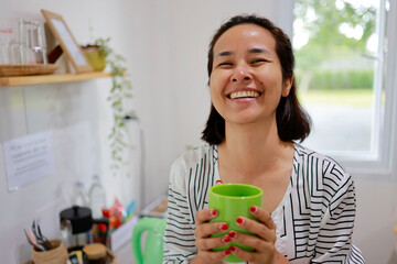Woman boils water to make coffee to drink in the morning.