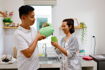 Woman and man boils water to make coffee to drink in the morning.