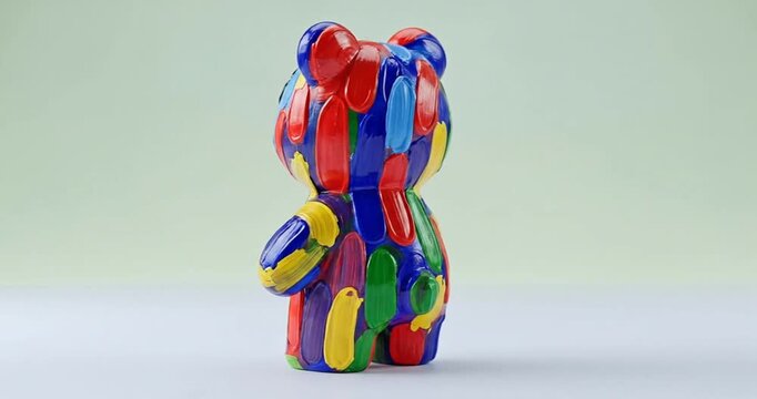 Colorful bear figurine painted with vibrant patterns against a soft pastel background