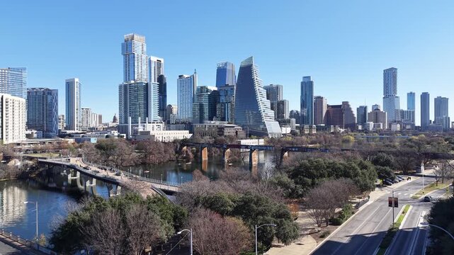 Austin Downtown and Skyline from Pfluger Pedestrian Bridge and MoPac Railroad Bridge over with Kayaks and Boats on Lady Bird Lake under Sunny Blue Sky