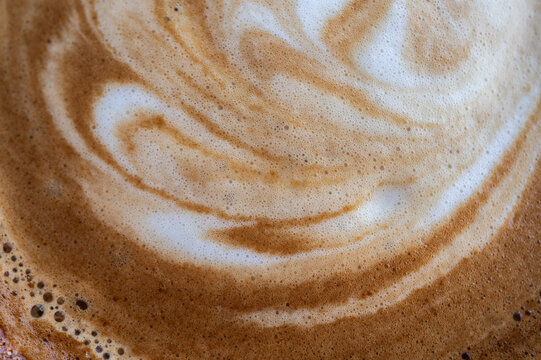 Full frame shot of the surface of hot latte coffee. A latte is a coffee drink made with espresso and steamed milk.