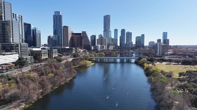 Austin Downtown and Skyline from Pfluger Pedestrian Bridge and MoPac Railroad Bridge over with Kayaks and Boats on Lady Bird Lake under Sunny Blue Sky