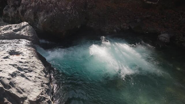 Slow Motion Side View of Small Glacial Waterfall Dropping into Turquoise Pool, Mountain Stream Cascading Over Rock Ledge, Fresh Nature Scene