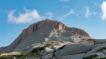 A panoramic summer travel view of a rocky mountain peak under a blue cloudy sky featuring a snow-capped national park valley and desert canyon nature landscape
