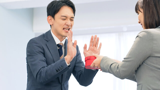 プレゼントを渡されて拒否するビジネスパーソン