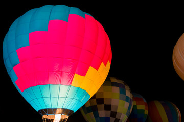 colorful hot air balloons glowing against dark night sky