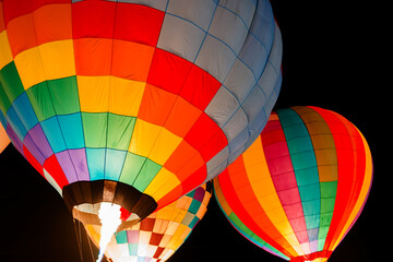 colorful hot air balloons glowing against dark night sky
