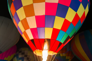 colorful hot air balloons glowing against dark night sky