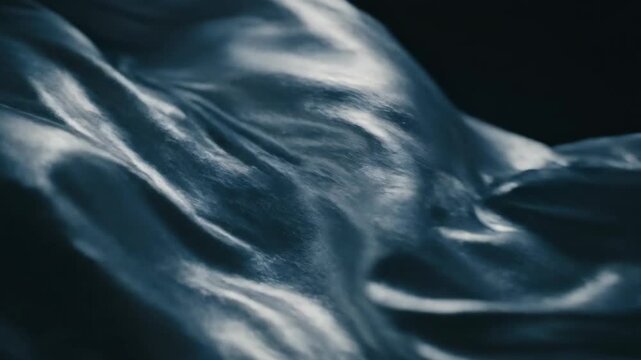 Dark blue fabric texture with subtle folds and creases on black background for fashion design