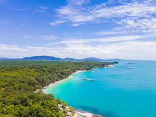 Obraz premium Aerial view of Membalong Beach in Belitung, Indonesia. A pristine tropical coastline featuring turquoise water, lush green forest, and giant granite rock formations.