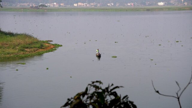 Deepor Beel a freshwater lake in Guwahati Assam with birds flying around  a fisherman in a country boat 1