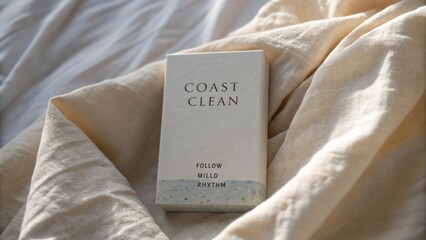 Minimalist coastal clean product packaging on soft beige fabric backdrop showcasing simplicity and calming elegance