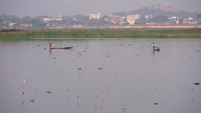 Deepor Beel a freshwater lake in Guwahati Assam with birds flying around two fisherman in a country boat with the city in the backdrop 2
