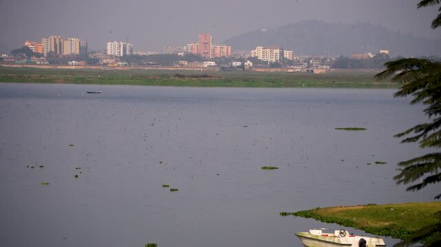Deepor Beel a freshwater lake in Guwahati Assam with birds flying over the water and the city in the background