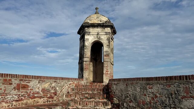 Historic stone sentry box or Garita on the fortress walls of Castillo San Felipe de Barajas in Cartagena, Colombia. Spanish colonial military architecture against blue sky