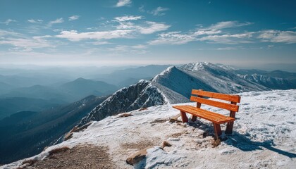 Wooden bench overlooks expansive snowy mountain range under bright clear sky