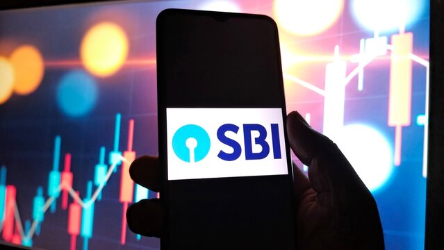 Smartphone displaying state bank of india sbi logo against a backdrop of financial stock market charts and bokeh lights