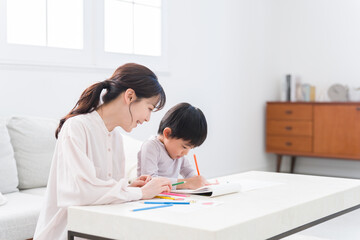 家でお絵描きする子供とママ