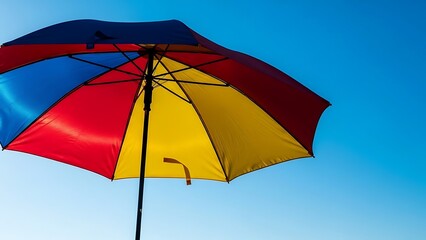 Obraz premium Colorful open umbrella against clear blue sky summertime weather concept