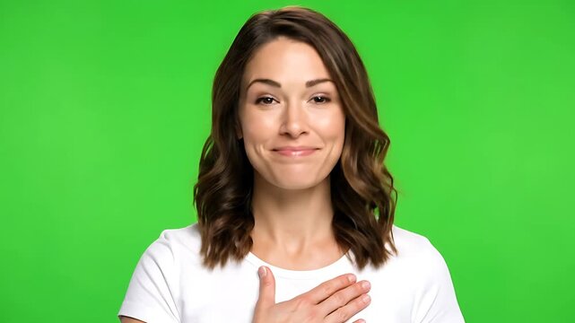 Smiling woman with hand on heart showing gratitude, appreciation, and sincerity on green screen background