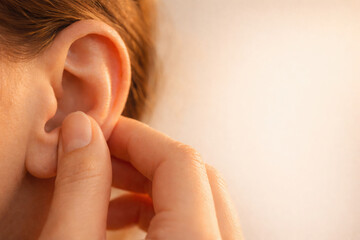 Close up view of person ear being gently touched, emphasizing somatic experience of grounding and connection