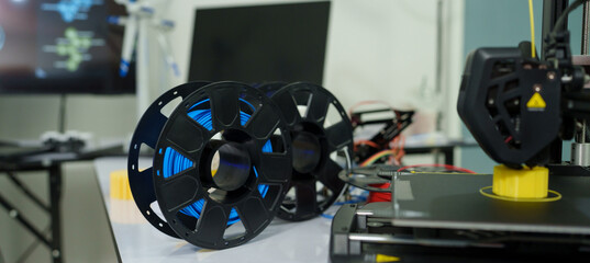 A 3D printer's cable reel prints a clear white plastic model using cutting-edge technology, focusing on a specific point, in the lab.	
