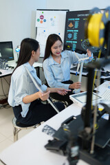 A female technician is sitting in the office, checking the operation of the solar panels and wind turbines.