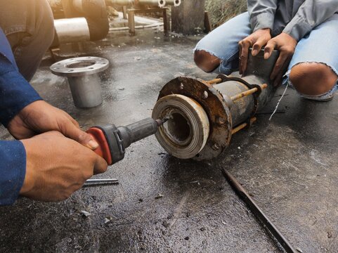 Cleaning the PPR pipe flange using sandpaper before installation by the project technician