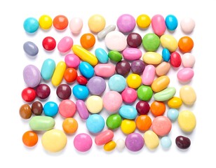 Obraz premium Assortment of colorful, hard-shelled candies scattered on a white surface, creating a vibrant and playful arrangement