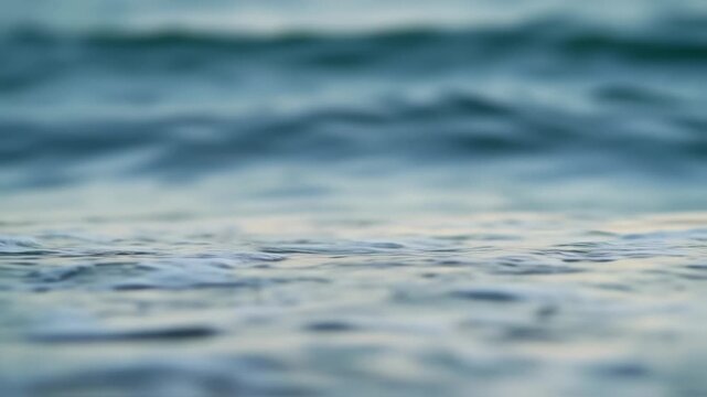 Serene ocean waves gently lap against the rocky shoreline in a captivating seascape video