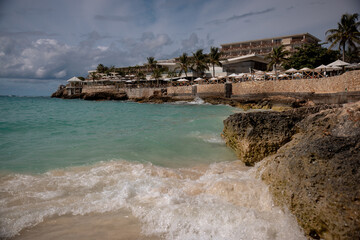 Resorts, waves and soft sand at Maho Beach in St. Maarten, a famous destination for sunbathing, swimming, and plane spotting.
