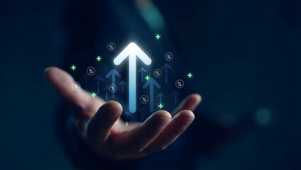 Businessman hand holding virtual glowing arrow up icon, representing business growth, financial performance, investment success and positive economic trend with percentage symbols