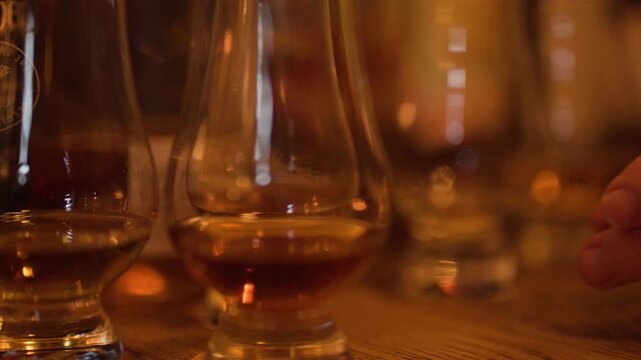 Close Up of Hand Reaching for Whisky Glass in Scottish Pub