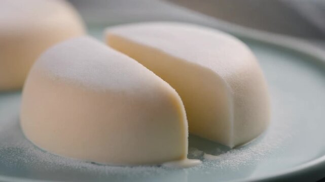 Slicing a Delicate White Mousse Dessert with a Knife on a Pastel Plate Highlighting Gourmet Preparation and Creamy Texture