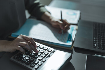 Accountant working on financial analysis using calculator and documents, representing accounting audit, budgeting, business reporting, data analysis, and professional financial management.