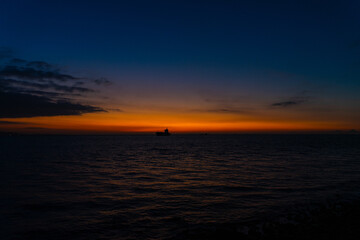 茜の朝焼け広がる夜明けの海