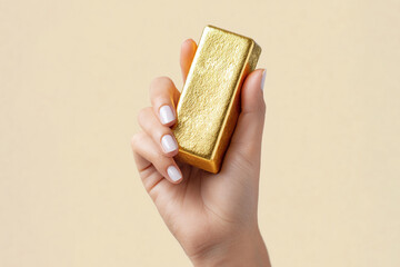 Human hand holding gold bar symbolizing wealth, investment, financial security, inflation hedge, and precious metal value.