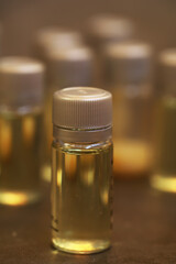 Collection of Small Transparent Bottles with Yellow Liquid Lined in a Row