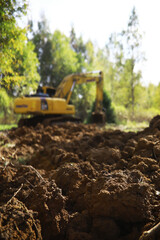Excavator in Action: Digging in a Forested Area for Land Development Projects