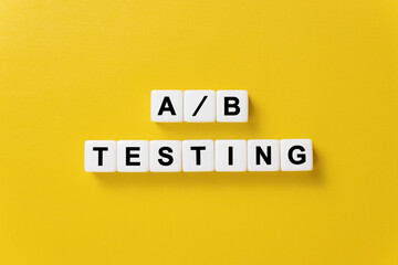Modern marketing buzzword - A and B testing. Top view on yellow table with blocks.