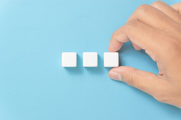 Hand holding a row of three blank dice