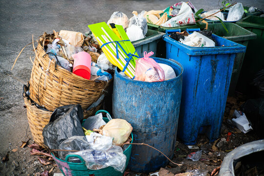 Overflowing Garbage Bins with Plastic Waste on Urban Street