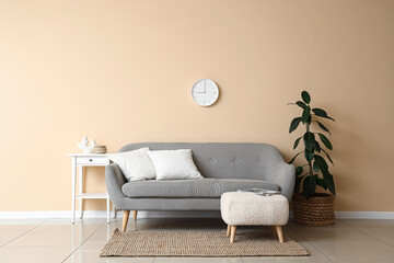 Interior of living room with clock, sofa and pouf