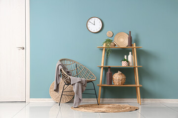 Interior of stylish room with clock, armchair and shelf unit