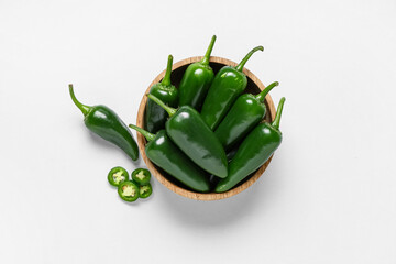 Wooden bowl with green jalapeno peppers on white background