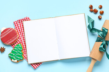 Blank recipe book with rolling pin, Christmas cookies and acorns on blue background