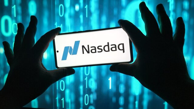 Person holding smartphone with nasdaq logo against binary code