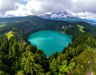 Aerial view of a crater lake with turquoise water and forested slopes