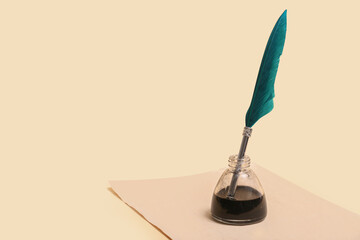 Old paper sheet with nib pen and inkwell on beige background