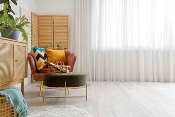 Light living room with pink armchair, pillows, chest of drawers and coffee table